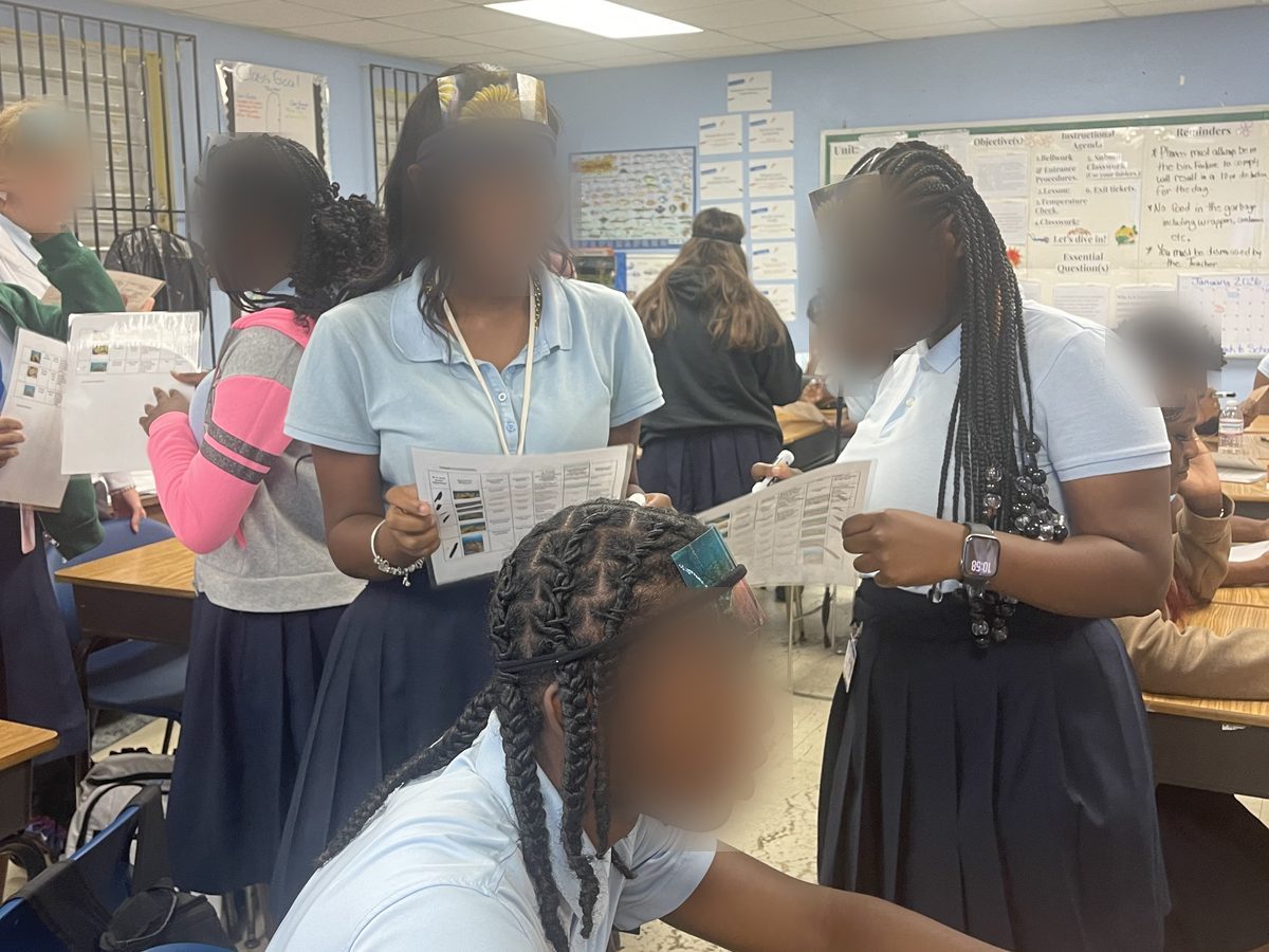 High school students working through printed coral reef activity sheets during a Corals in the Classroom lesson
